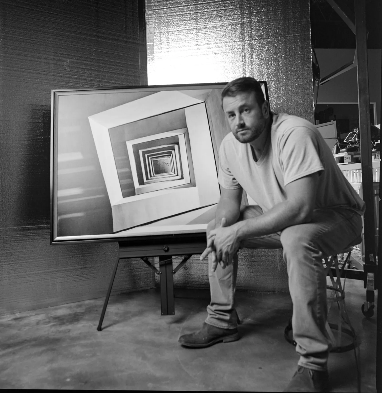Joe Sale in his studio beside one of his framed fine art pieces