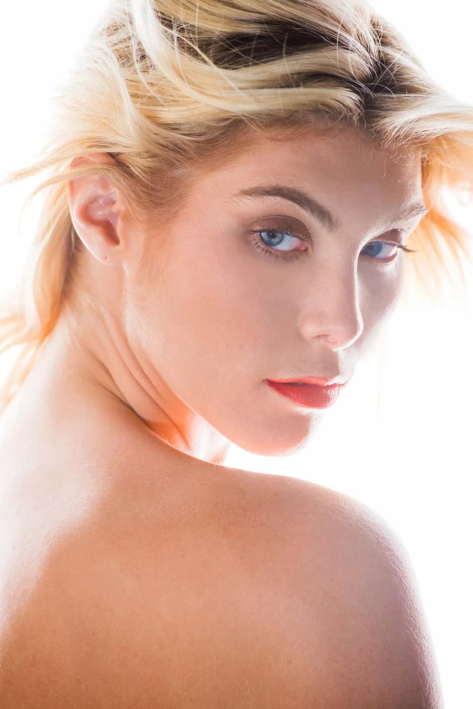 High-key beauty portrait, windswept blonde hair