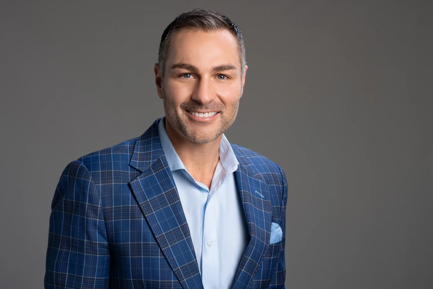 Man in a plaid blue suit, studio headshot