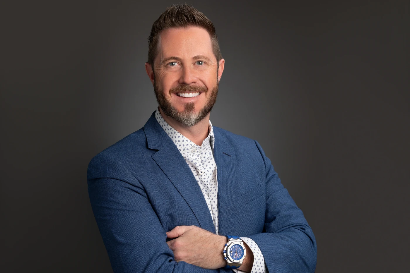 Bearded man in a blue blazer, arms crossed
