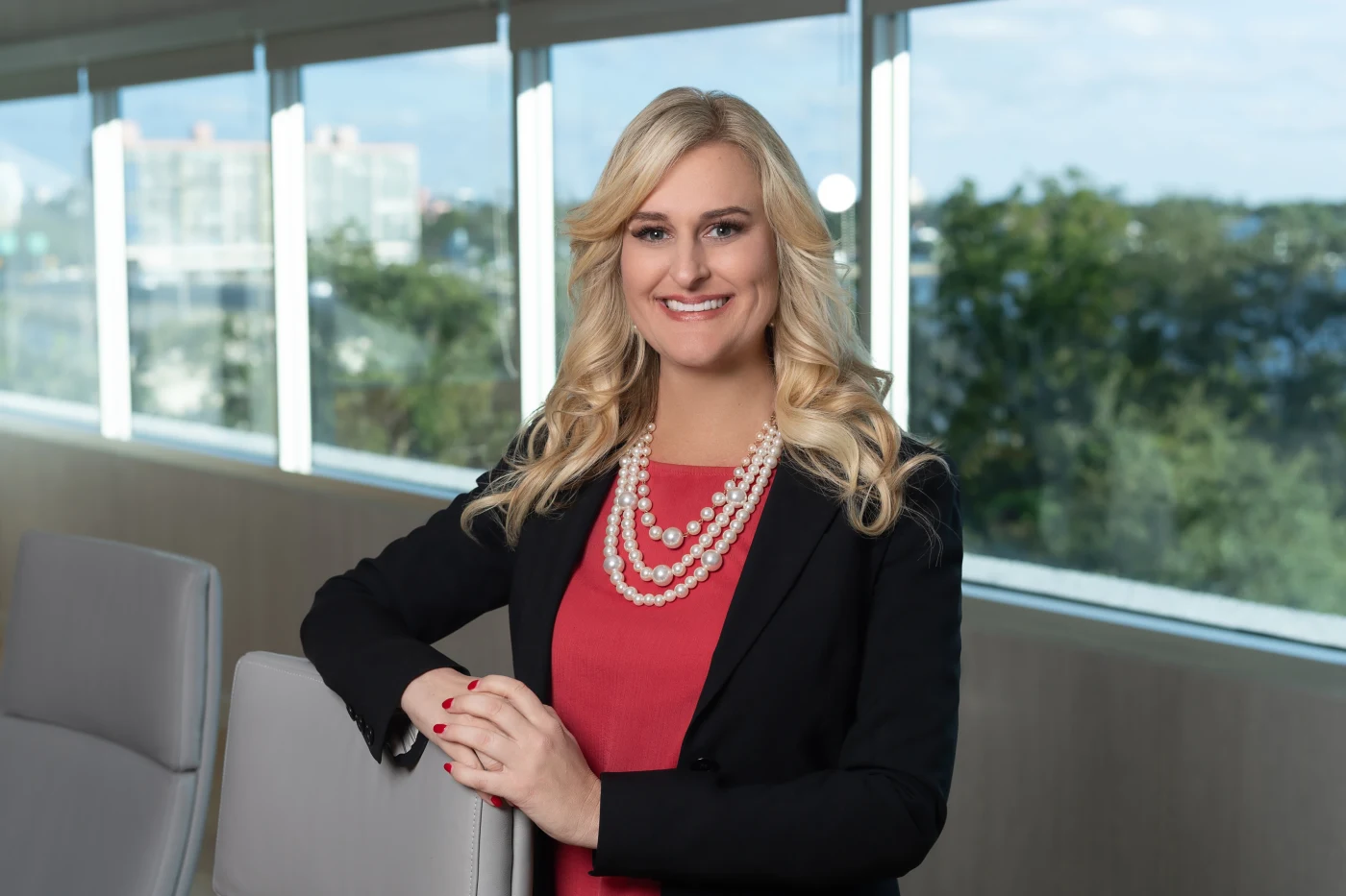 Woman in red and pearls posed in a bright office