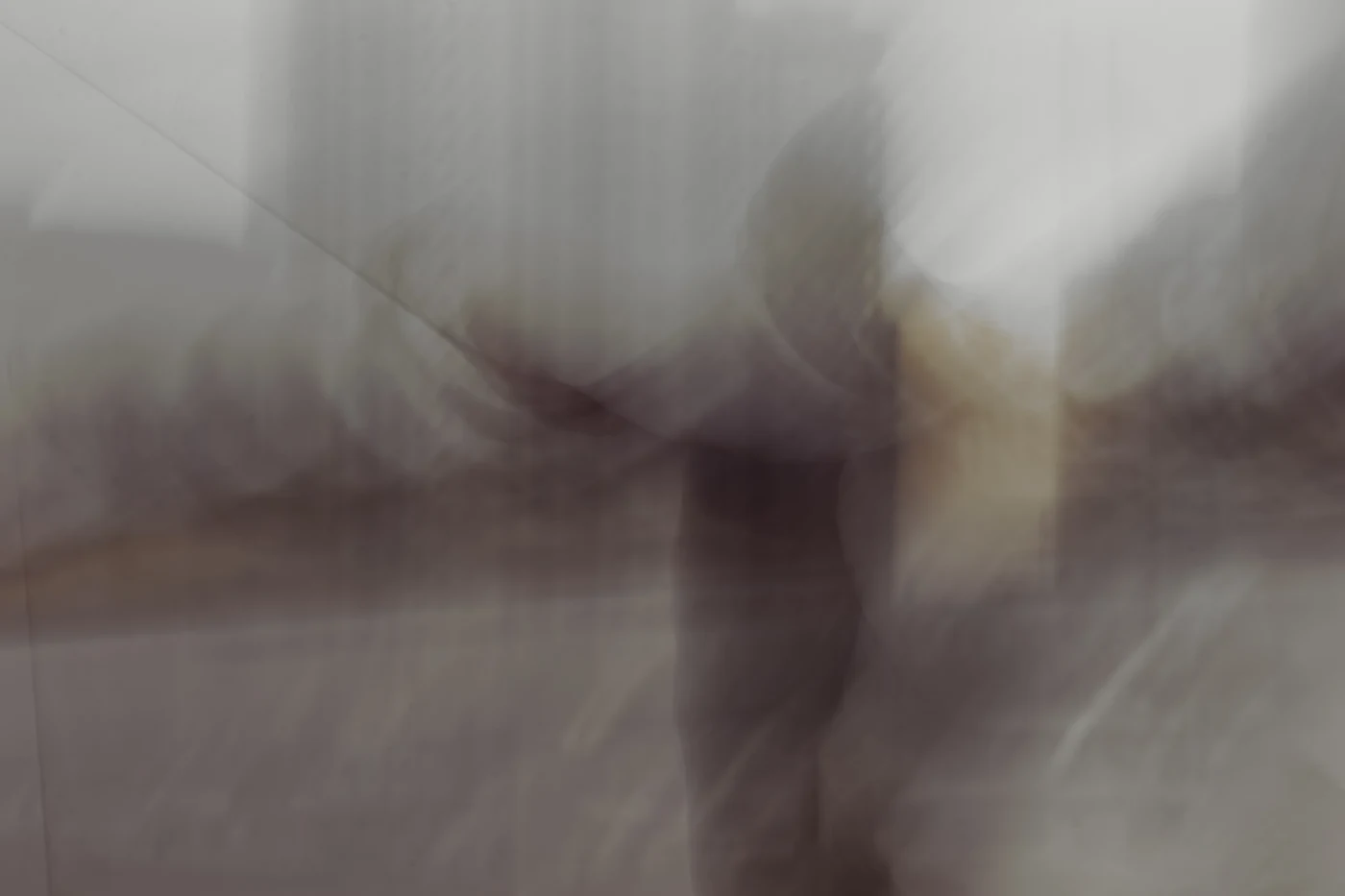 Muted impressionistic motion study of a figure in the city