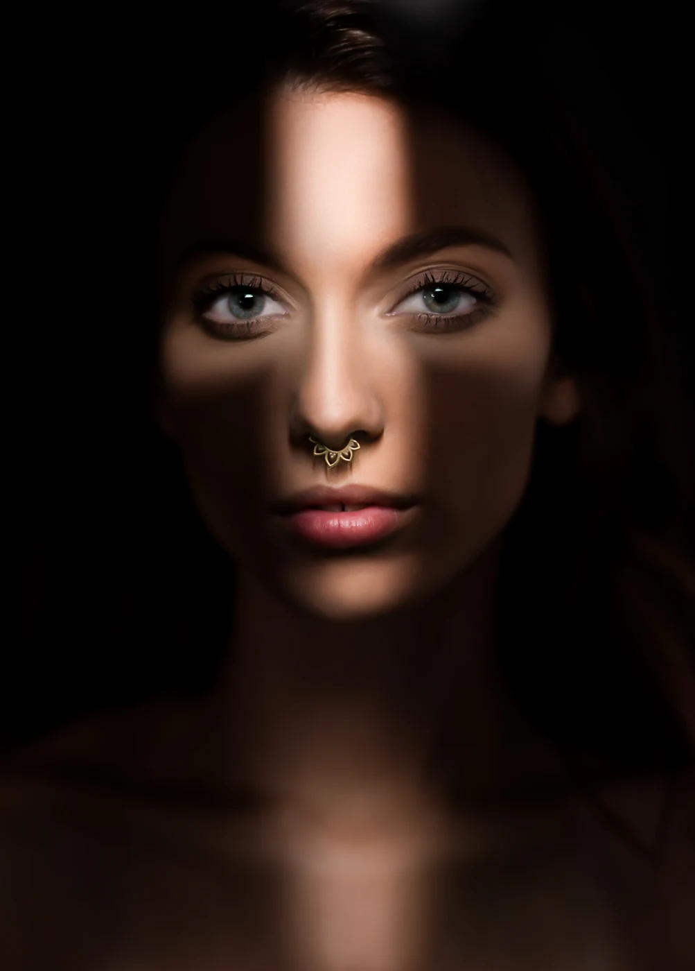 Dramatic portrait of a woman lit by a single blade of light