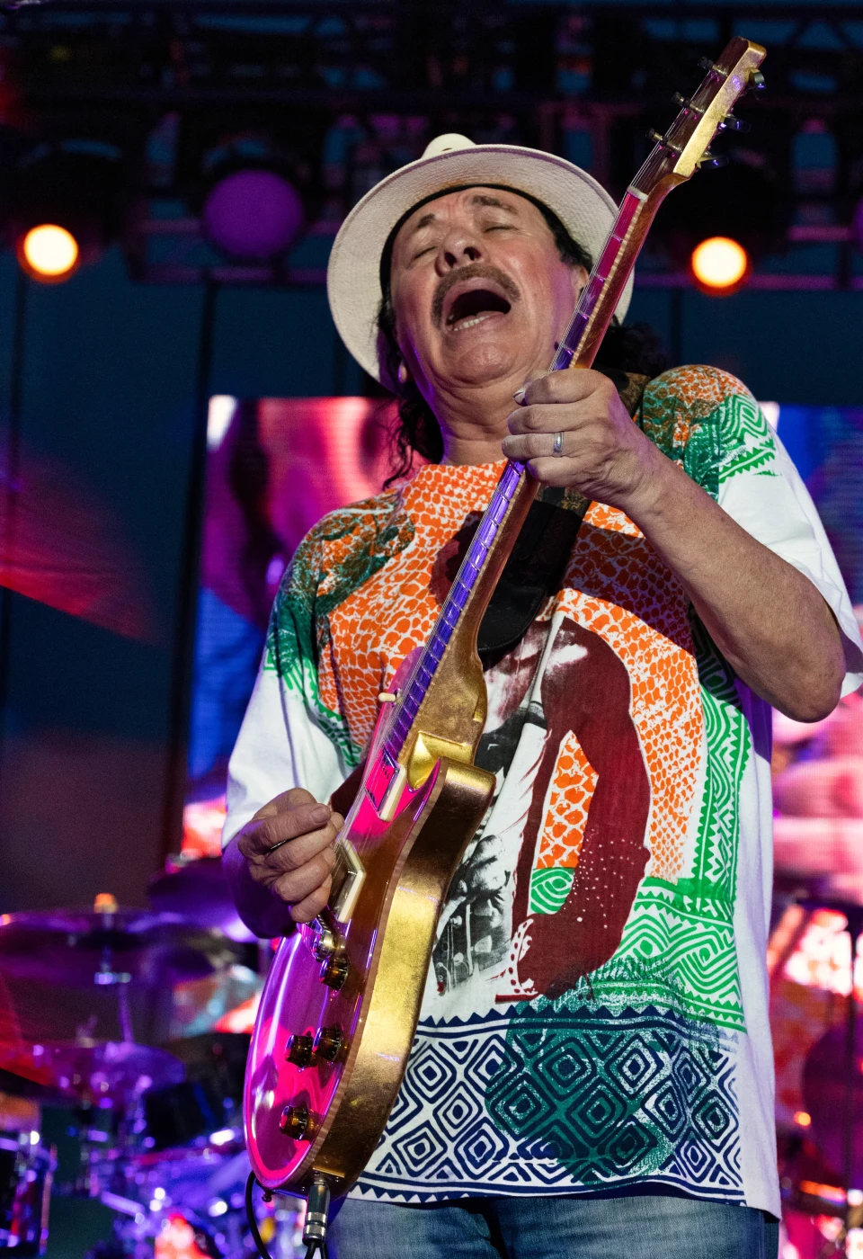Guitarist leaning into a solo, vertical concert photograph