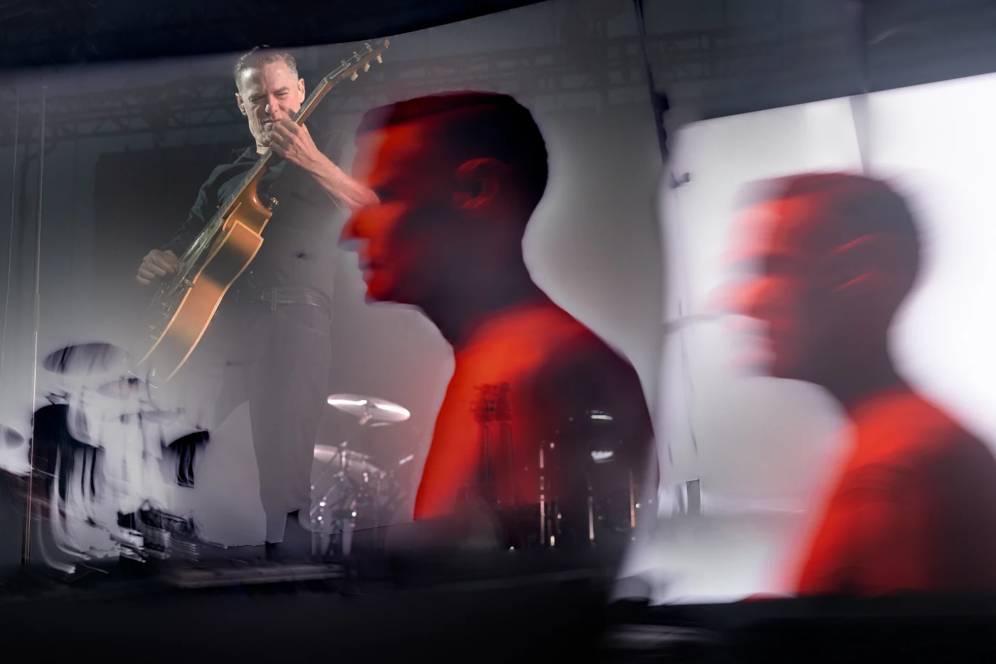 Multiple-exposure art blend of a guitarist performing in red light